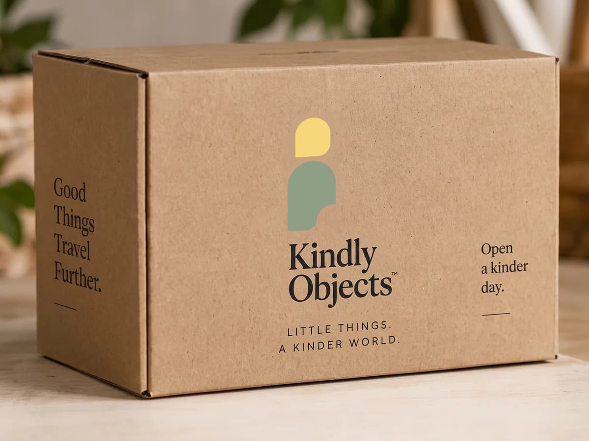 Kraft shipping box printed with the Kindly Objects icon and wordmark — AI concept render